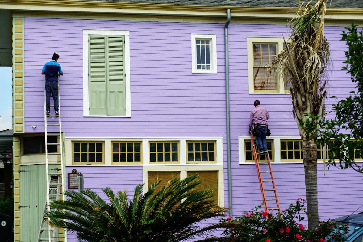 Two professional painters at work on a home's exterior.